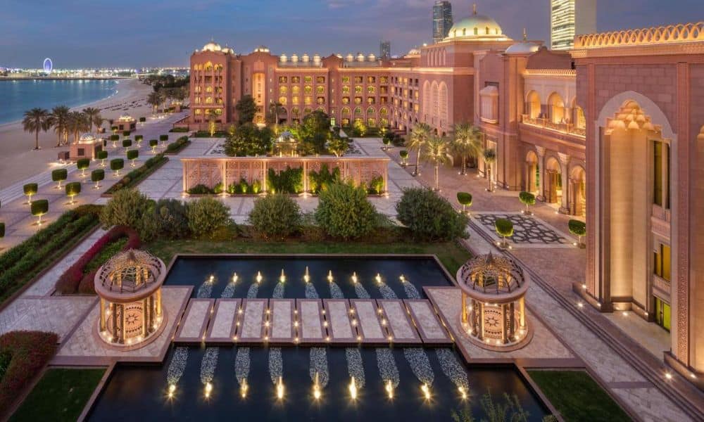 Emirates Palace Mandarin Oriental at dusk, with fountains and gardens leading to the beach