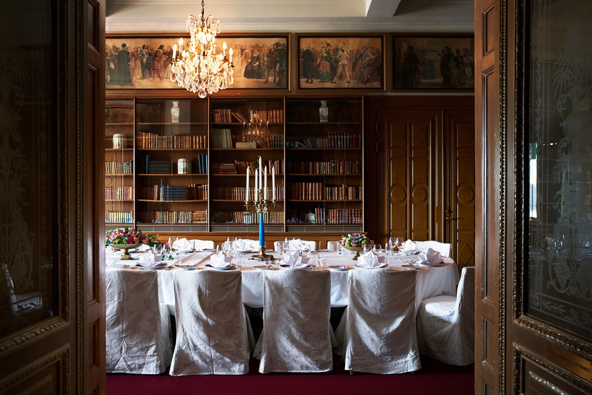 Private dining room with bookshelves and a chandelier at Grand Hôtel Stockholm