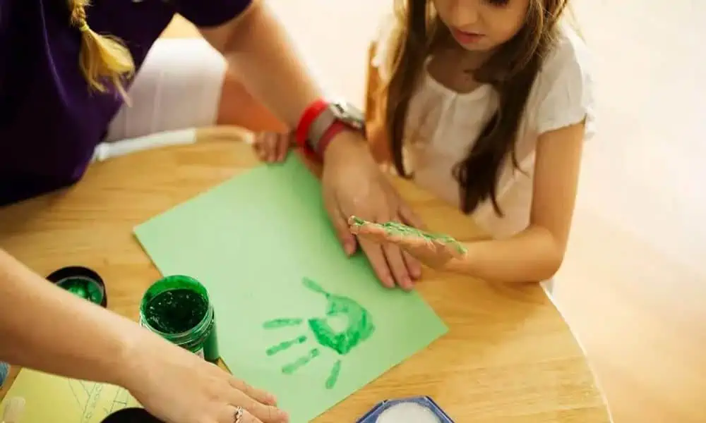 Child painting handprints with a kids' club host at Niyama Private Islands Maldives