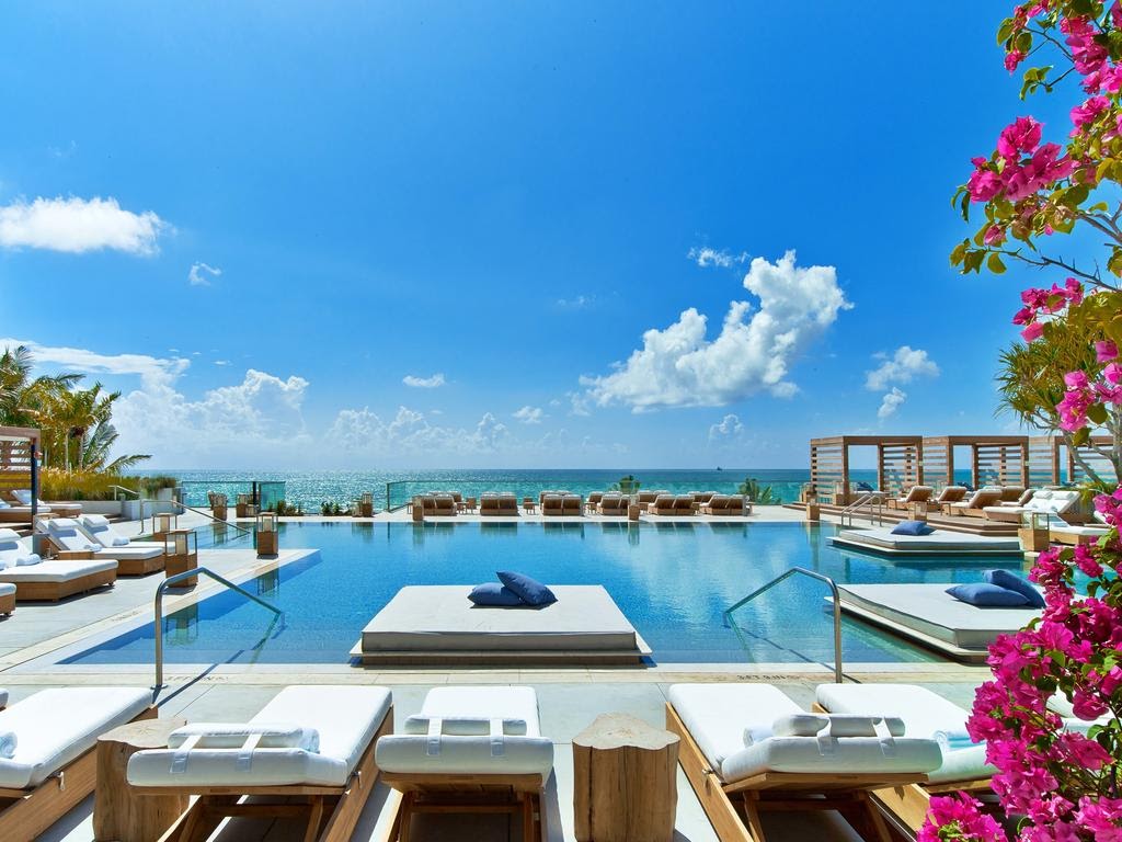 The pool deck at 1 Hotel South Beach with daybeds and the Atlantic behind