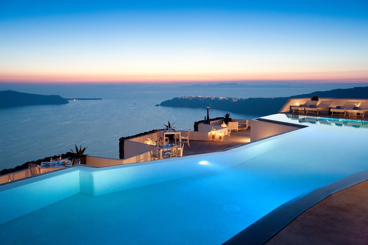 Grace Hotel's infinity pool above the Santorini caldera at dusk