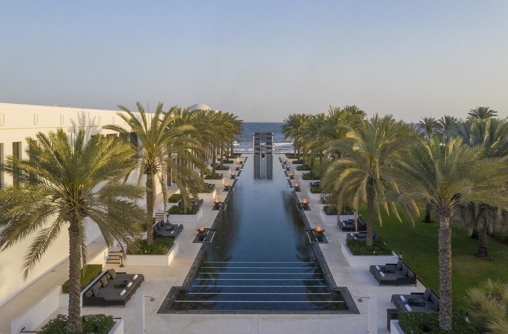 The Long Pool at The Chedi Muscat lined with palms and cabanas
