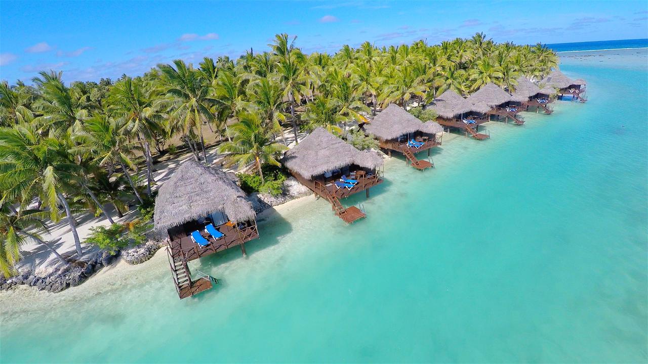 Overwater bungalows along the beach at Aitutaki Lagoon Private Island Resort