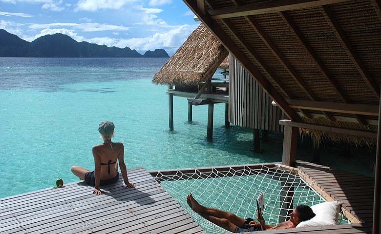 Overwater deck with a net hammock at Misool
