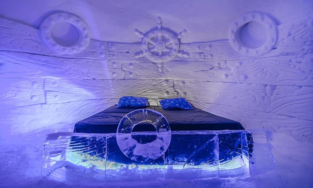 Snow room at Kirkenes with a ship's wheel and portholes carved into the snow wall and an ice bed (a past design)
