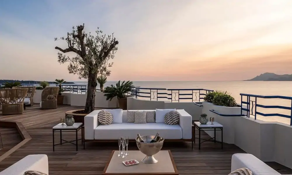 Rooftop terrace of a penthouse at Hôtel Martinez in Cannes at sunset, overlooking the Bay of Cannes