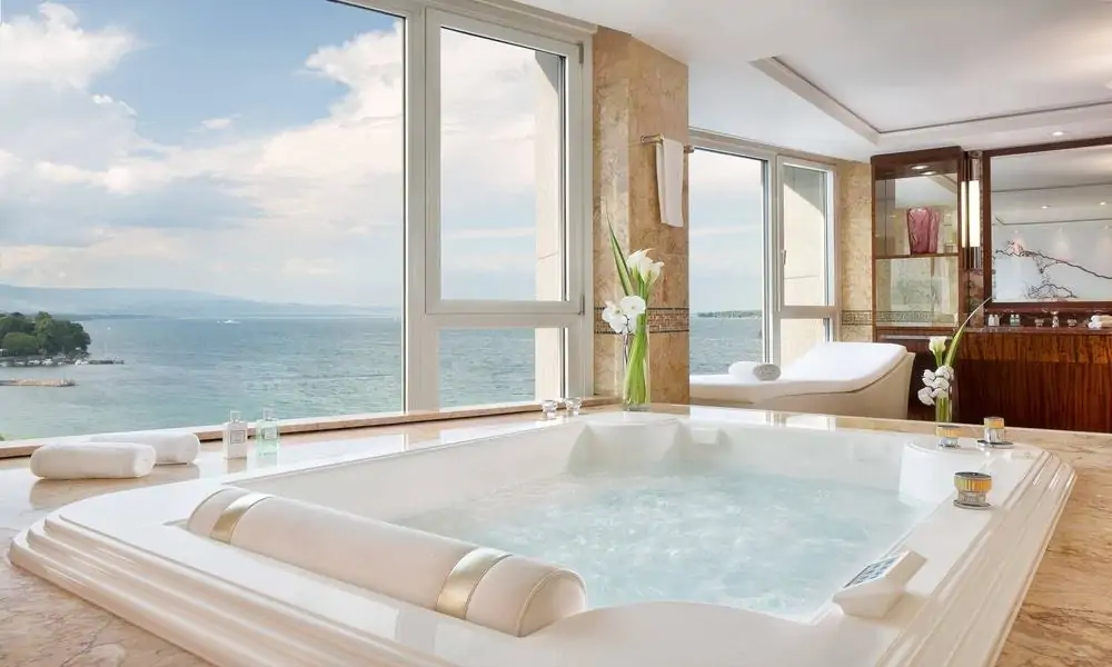 Jacuzzi bath in the Royal Penthouse Suite at Hotel President Wilson, with windows over Lake Geneva