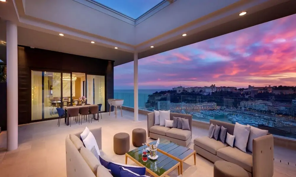 Covered terrace of a Diamond Suite at Hôtel de Paris Monte-Carlo at dusk, overlooking Port Hercule