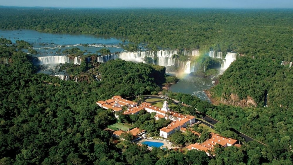 Belmond Hotel das Cataratas seen from the air, with the Iguaçu Falls and the surrounding forest behind it