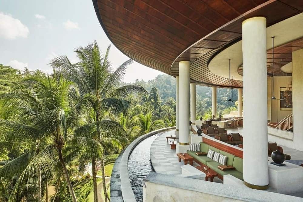 The curved main building at Four Seasons Resort Bali at Sayan, above palm trees in the Ayung River valley