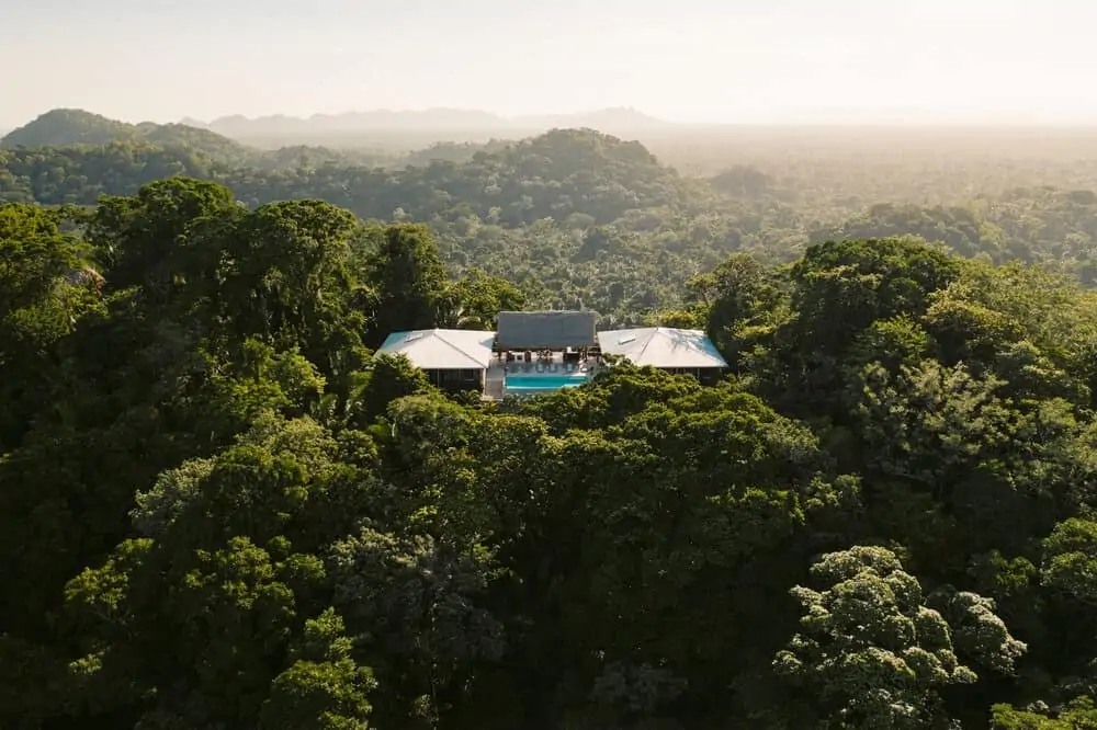 Aerial view of a Copal Tree Lodge villa with a pool in the rainforest canopy