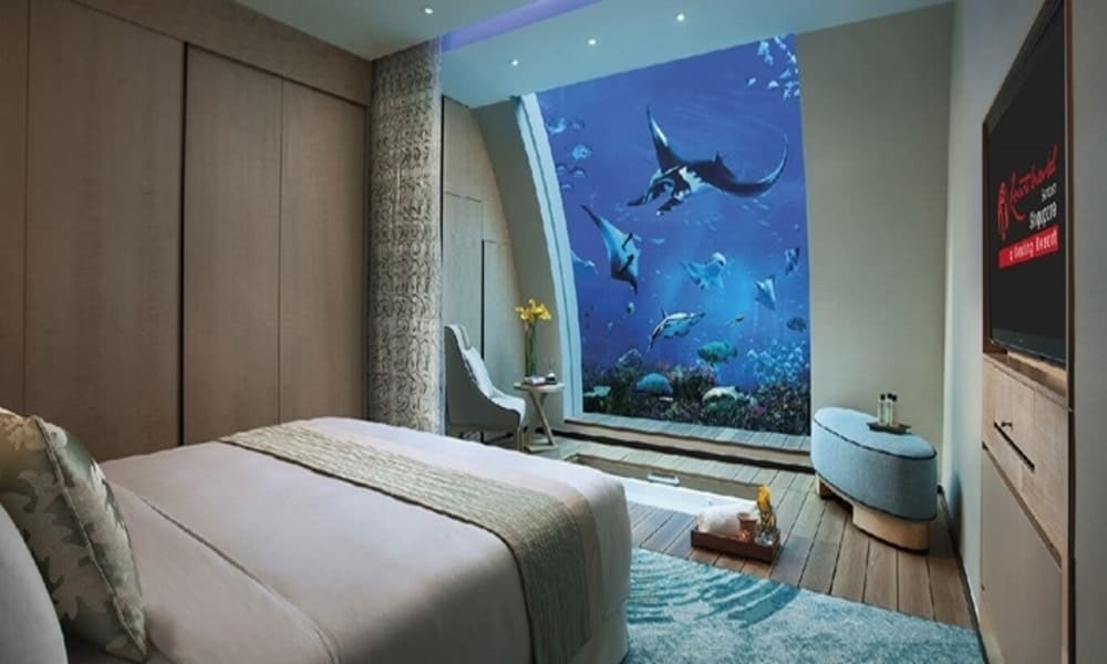 Lower-floor bedroom of an Ocean Suite at Resorts World Sentosa, with manta rays in the aquarium window