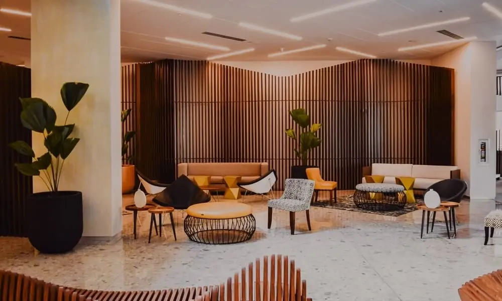 Hotel lobby with lounge seating, plants and a wooden slatted wall