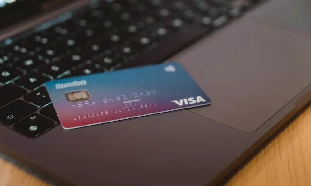 Visa payment card resting on a laptop keyboard